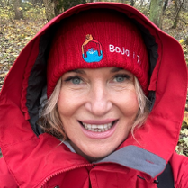 Uśmiechnięta kobieta ubrana w czerwoną czapkę i czerwony kaptur.