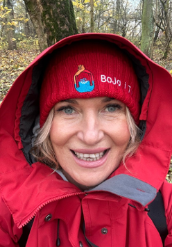 Uśmiechnięta kobieta ubrana w czerwoną czapkę i czerwony kaptur.