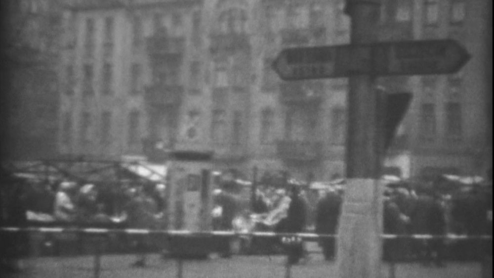 Poruszony, biało-czarny kadr z filmu 8-milimetrowego. Rynek Jeżycki w dniu handlowym.