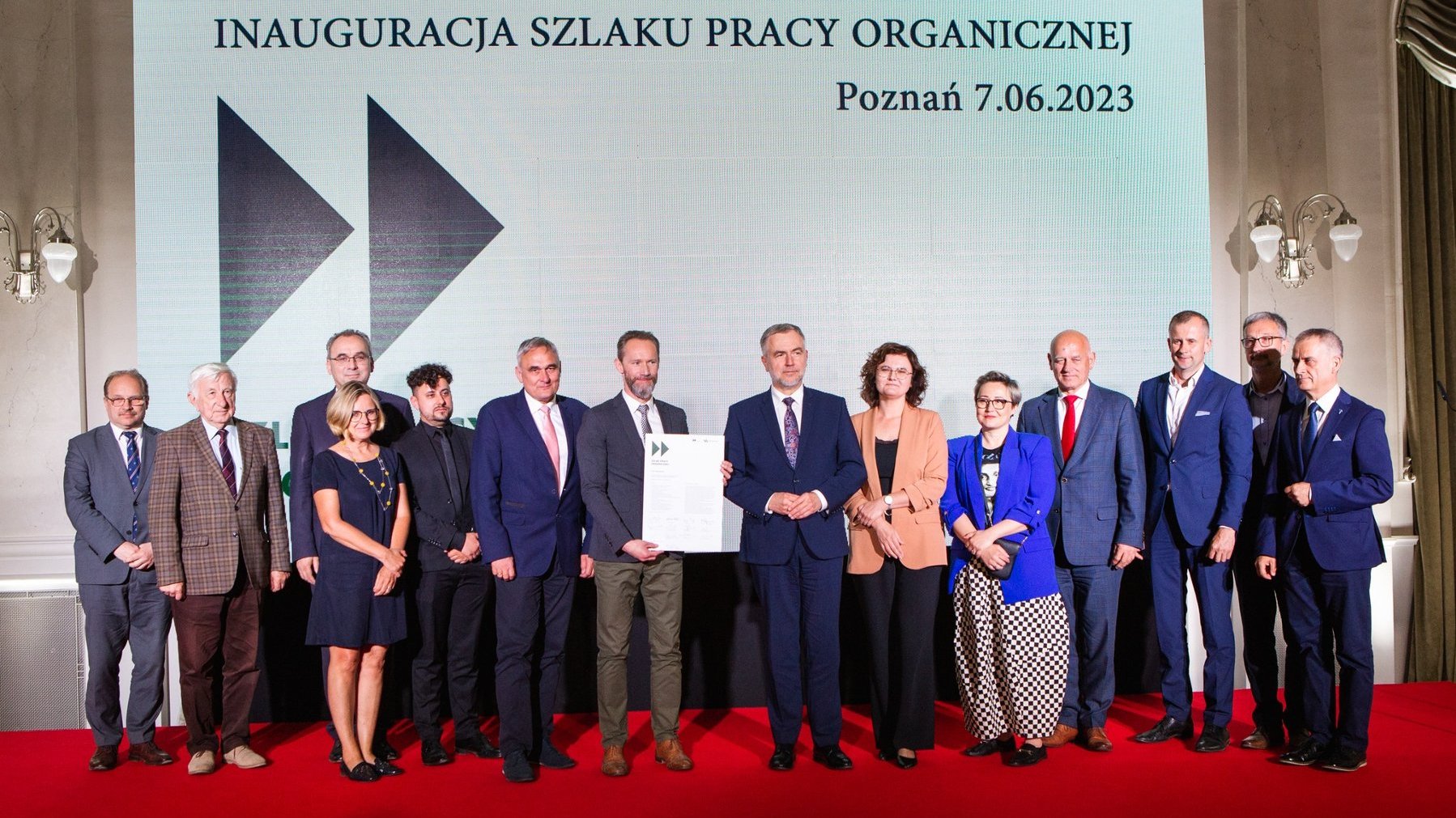 Na scenie 14 osób, kobiet i mężczyzn, dyrektorów instytucji, którzy wcześniej podpisali list intencyjny ws. utworzenia szlaku