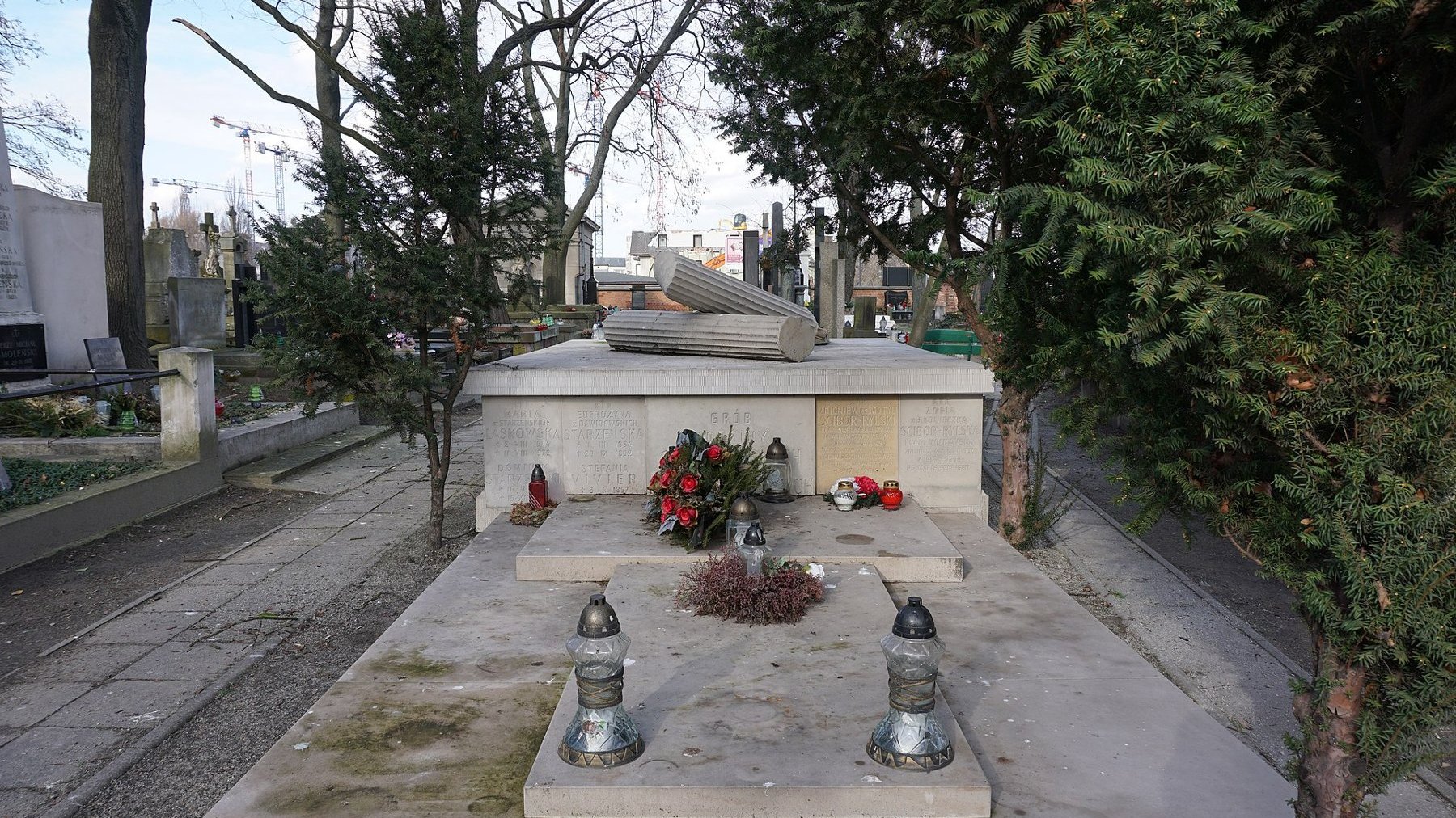 Duży grobowiec rodziny, na płycie nagromnej przewrócone kolumny w stulu greckim, z przodu nazwiska pochowanych w grobowcu z datami urodzin i śmierci