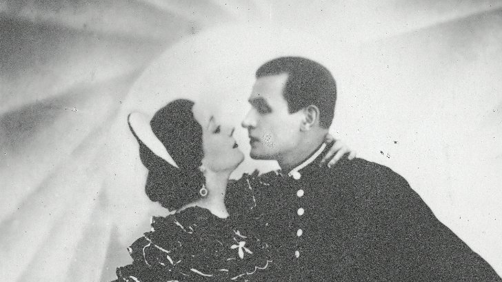 Czarno-białe zdjęcie tańczącej pary, kobiety i mężczyzny, wpatrzonych w siebie.