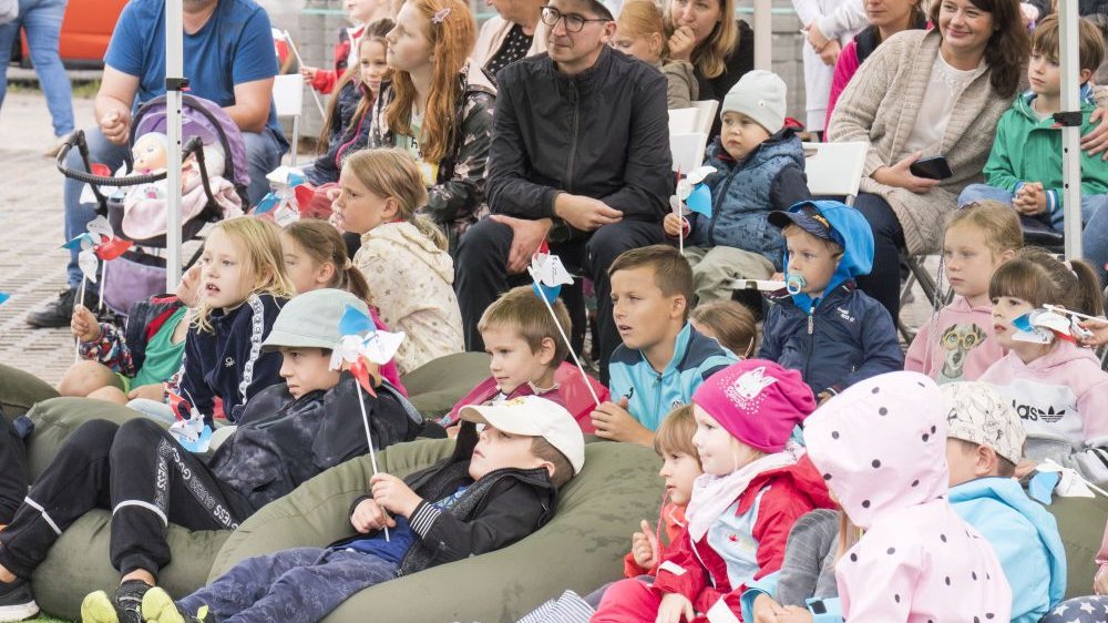 Widownia oglądająca spektakl, dominują dzieci w różnym wieku, niektore siedzą na fotelach rozstawionych w pierwszym rzędzie.