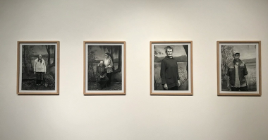 Cztery fotografie portretowe w ramach, które wiszą na ścianach.