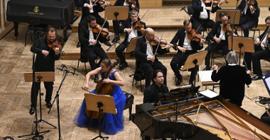 Soliści Krzysztof Jakowicz i Karolina Jaroszewksa Georgijs Osokins na scenie, za nimi towarzysząca im orkiestra.