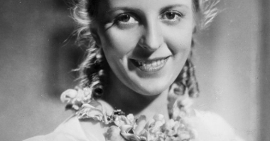 Czarno-biały kadr filmowy z podpisem aktorki. To jej uśmiechnięty portret.