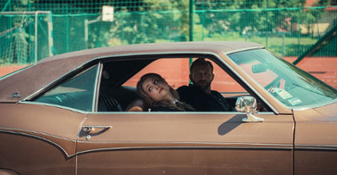 Mężczyzna i młoda dziewczyna siedzą w samochodzie typu klasyczny chevrolet.