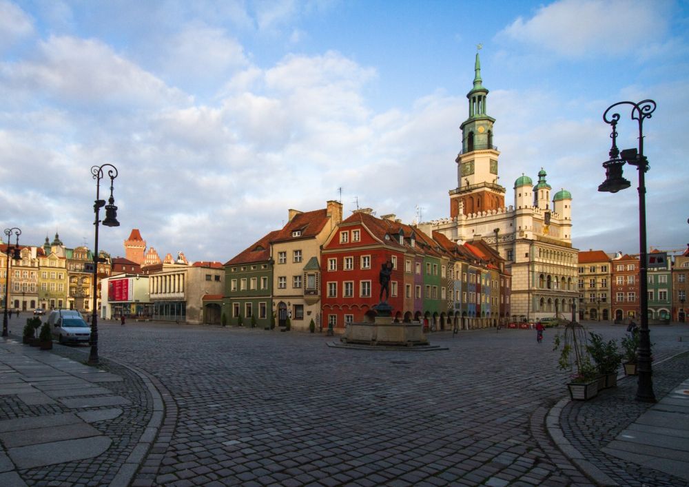 Centrum Starego Rynku z daleka - widać zabytkowe kamienice otaczające ratusz oraz brukowane uliczki. Zdjęcie zrobione w pogodny dzień, niebo jest błękitne. - grafika artykułu