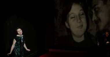 Uśmiechnięta aktorka śpiewa z zamkniętymi oczami. Po prawej archiwalne zdjęcie pary na ekranie.