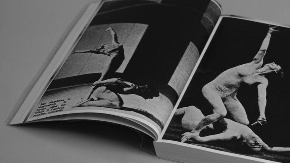 Czarno-białe zdjęcie otwartej, nagrodzonej książki. Na zdjęciach w środku tancerze PTT.
