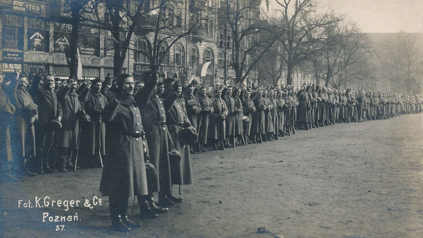 Żołnierze w szeregu, wznoszą dłonie z dwoma palcami w górze, w geście przysięgi