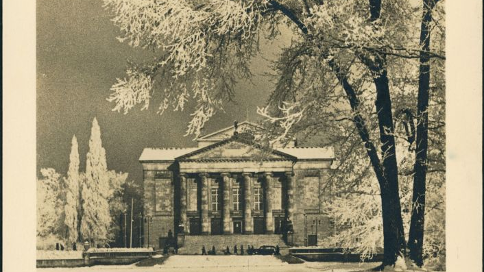 Budynek teatru wraz z górującym nad nim drzewem na starej fotografii.