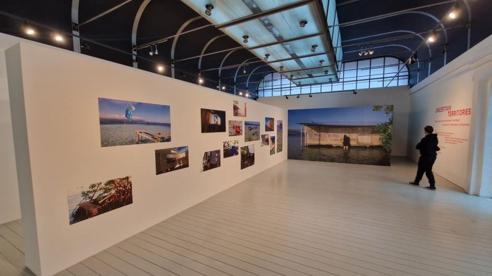 Wejście na wystawę. Na ścianach wiszą fotografie w różnych rozmiarach.