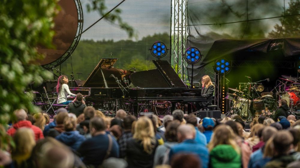 Dwoje pianistów podczas koncertu na plenerowej scenie.