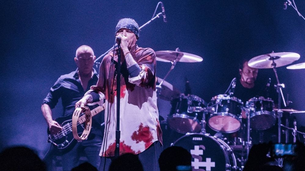 Wokalista, basista i perkusista grają koncert.