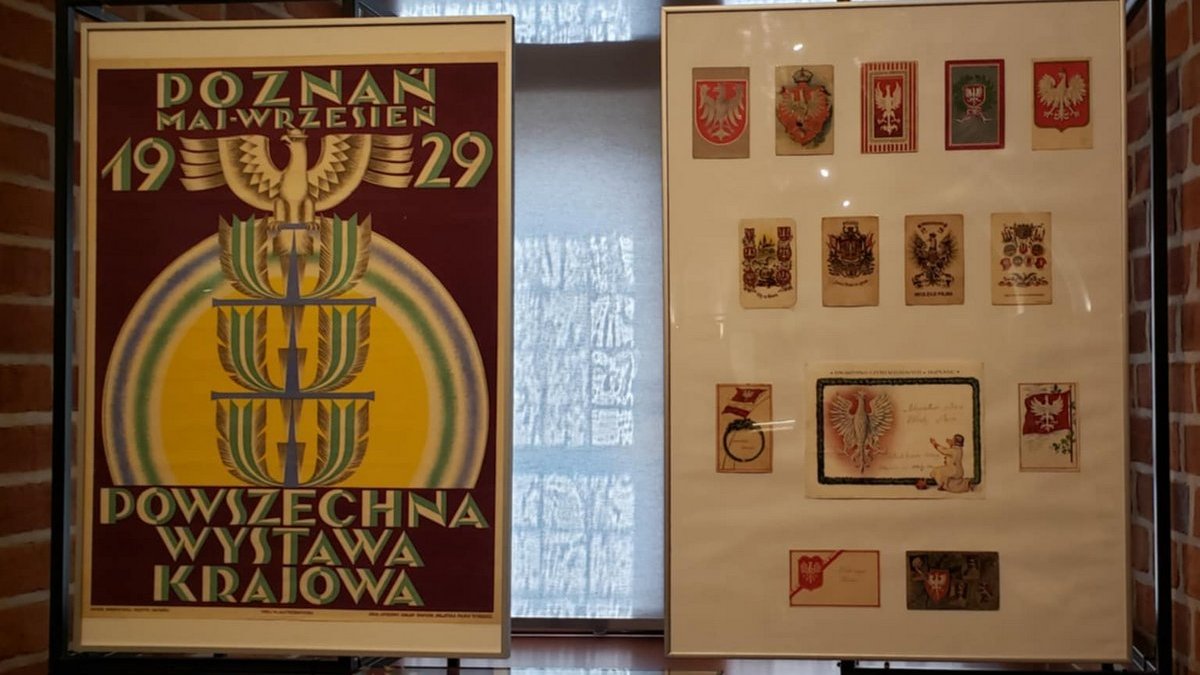 Plakat reklamowy oraz tablica przedstawiająca karty pocztowe z orłem