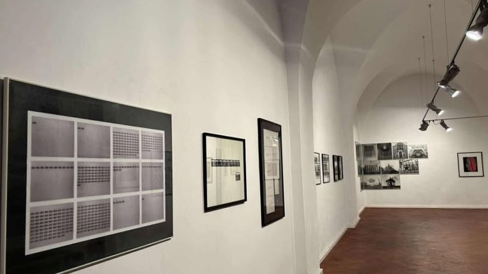 Czarno-białe fotografie na białych ścianach galerii.