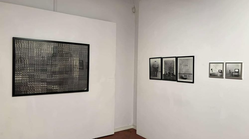 Czarno-białe fotografie na białych ścianach galerii.