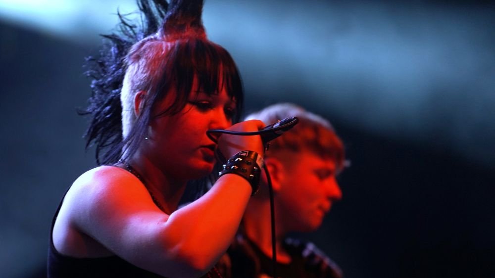 Dziewczyna z irokezem i gitarzysta podczas koncertu punkowego.