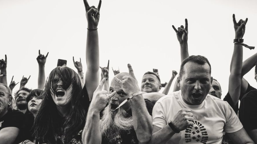 Czarno-białe zdjęcie fanów na koncercie rockowym.