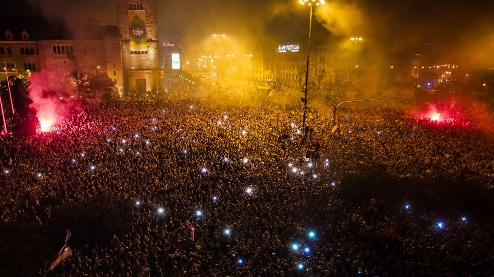 Kibice tłumnie świętują zwycięstwo po zmroku.
