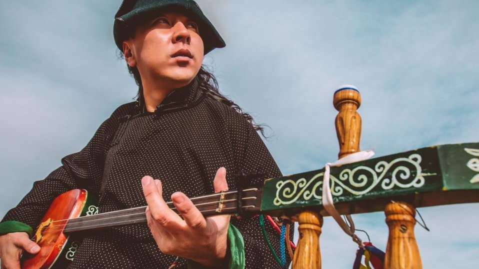 Muzyk na tle stepu z instrumentem w ręku.