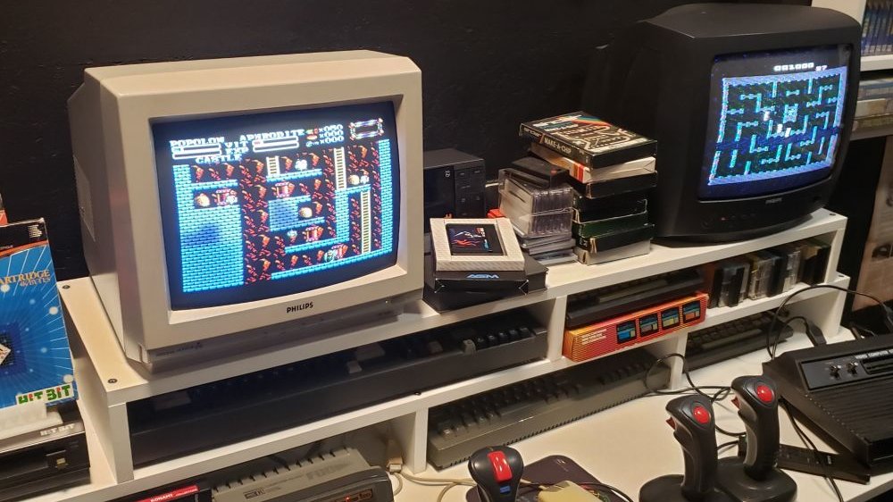 Zabytkowy sprzęt komputerowy: komputery, joysticki, głośniki.