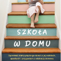 Dziecko siedzące na kolorowych schodach i trzymające książkę w ręku.