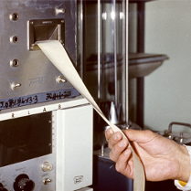 Z maszyny wychodzi taśma paieru z wydrukie. Taśmę trzyma dłoń najprawdopodobniej lekarza.