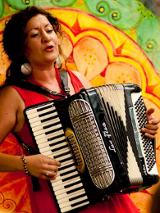 Artystka z akordeonem na kolorowym tle.