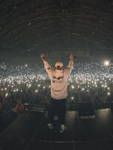 Wieczór. Pezet na scenie. Przed nim publiczność z włączonymi latarkami smartfonów.