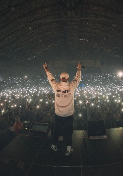 Wieczór. Pezet na scenie. Przed nim publiczność z włączonymi latarkami smartfonów.