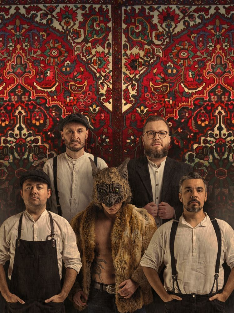 Pięciu mężczyzn na tle wzorzystego dywanu.