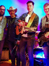 Na zdjęciu członkowie zespołu, po lewej napisy informujące o wydarzeniu