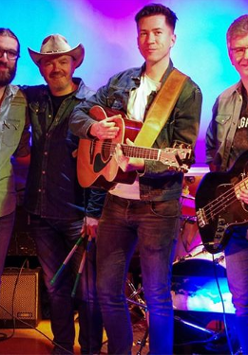 Na zdjęciu członkowie zespołu, po lewej napisy informujące o wydarzeniu