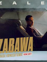 Na grafice artysta siedzący w samochodzie. W dolnej części grafiki napis zabawa.