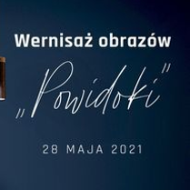 Pokój z granatową ścianą. Na ścianie zawieszony kolorowy obraz. Pod obrazem kanapa.