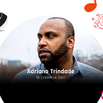 Adriano Trindade patrzy w dal, w tle miasto.