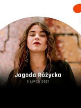 Kobieta z długimi brązowymi włosami patrzy w obiektyw.