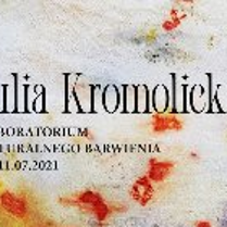 Biały materiał z kolorowymi plamami. Na nim napis.