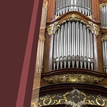 Napis na bordowym tle, z prawej strony organy.