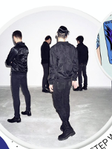 Czterech mężczyzn stoi tyłem, ubrani na czarno.