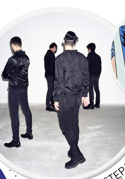 Czterech mężczyzn stoi tyłem, ubrani na czarno.