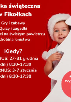 Dziecko w czapce św. Mikołaja wygląda zza choinki.