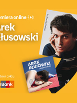 Plakat ze zdjęciem artysty i okładką płyty w prawej części. W części lewej u góry białe napisy na pomarańczowym tle.