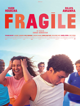 Na pierwszym planie młody chłopak o ciemnych włosach, za nim stoi roześmiana dziewczyna, w tle grupa młodych osób. Czerwono-pomarańczowy tytuł na jasnoniebieskim tle.