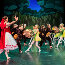 dziewczynka w czerwonej czapeczce razemz innymi dziećmi w kostiumach niedzwiedzi i pszczoł