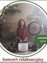 Kobieta w bordowej bluzce siedzi na podłodze. Przed nią stoją misy i gongi do grania.