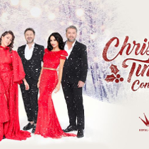 Trzech mężczyzn w garniturach oraz dwie kobiety w czerownych sukienkach pozują na tle śnieżnego lasu. Obok czerowne napisy.