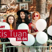 Czworo ludzi trzymający balony w rękach pozują na tle podówrka kamienicy.